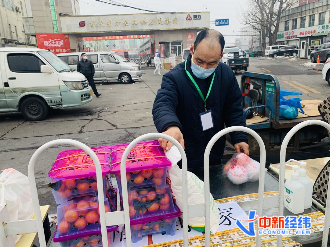 首农东方食品供应链集团门口志愿者正在派送物资 中新经纬 王玉玲 摄